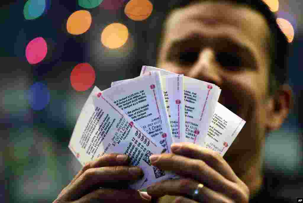 Chad Cuneo displays Mega Millions lottery tickets he purchased at a newsstand in Philadelphia, Pennsylvania. Superstition didn't deter players hoping that Friday the 13th will bring them good luck in the game.