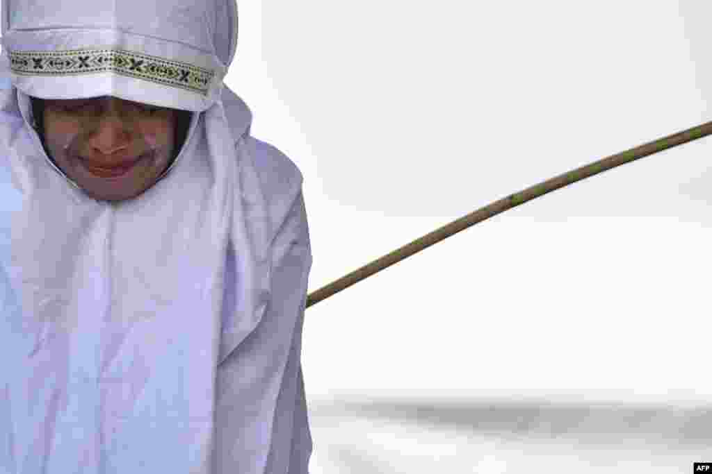 A woman is whipped in public in Banda Aceh in Indonesia's staunchly conservative Aceh province as punishment for being too close to the opposite sex.