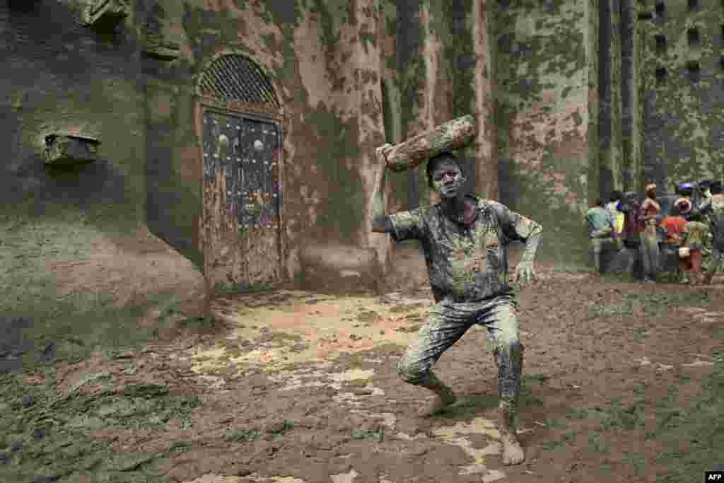 A man takes part in the annual rendering of the Great Mosque of Djenne in central Mali, April 28, 2019. The rendering of the building with banco (a mixture of soil and water, with rice bran, shea butter and baobab powder) made by the city's inhabitants, helps to protect the mosque from bad weather ahead of the rainy season.
