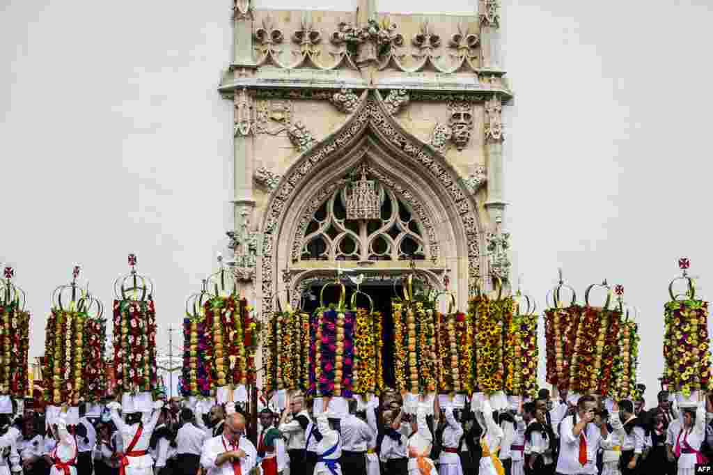 Participants of "Festa dos Tabuleiros" (trays party) carry the trays on their heads during the parade in Tomar, Portugal, July 7, 2019. Since the 16th century, Tomar citizens celebrate the day of the Holy Spirit every four years in a parade with the crowns known as "trays" that are adorned with colored paper flowers and bread and transported by girls from the various parishes of Tomar.