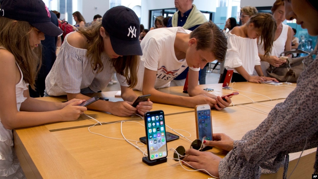 FILE- Customers browse in an Apple store in New York, Aug. 2, 2018. On Thursday, the Commerce Department issued its July report on consumer spending, which accounts for roughly 70 percent of U.S. economic activity.