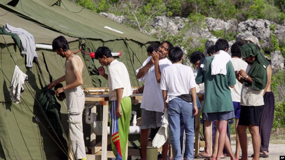 FILE - Men shave, brush their teeth and prepare for the day at a refugee camp on the Island of Nauru, Sept. 21, 2001.