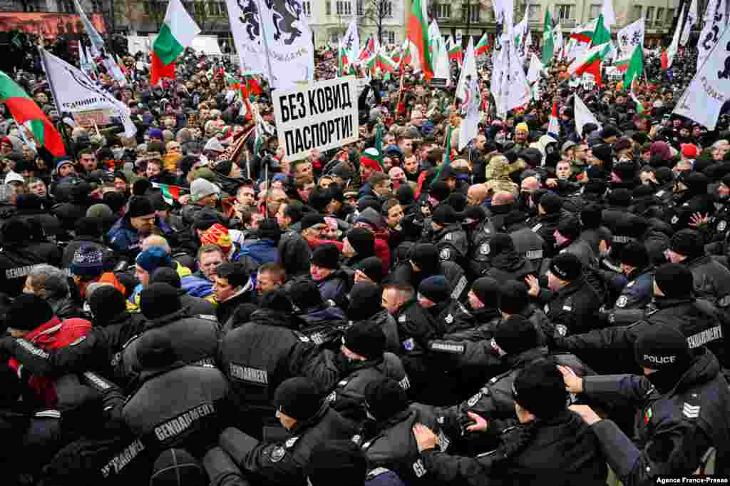 About 2,000 protesters, who don't wear masks or adhere to social distancing, push against police cordons as they try to enter Bulgaria's parliament building during a demonstration organized by the nationalist Vazrazhdane political party, which is pushing for the abolition of the COVID-19 health pass in Sofia.