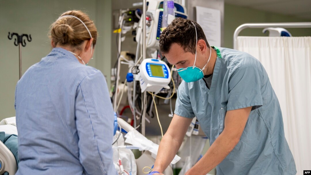 This US Navy handout photo obtained April 6, 2020 shows Lt. Wade Miller, from Orlando, Florida, treating a patient aboard the hospital ship USNS Mercy (T-AH 19)on April 4, 2020 in Los Angeles, California. - Mercy deployed in support of the nation's COVID-