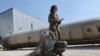 A member of the Israeli military stands next to an Iranian ballistic missile which fell in Israel on the weekend, during a media tour at the Julis military base near the southern Israeli city of Kiryat Malachi on April 16, 2024.