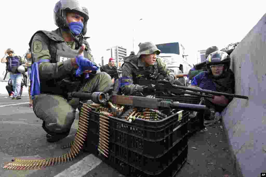 Soldiers loyal to Venezuelan President Nicolas Maduro join opposition leader Juan Guaido in his campaign to oust Maduro's government, on an overpass outside La Carlota military airbase as they confront loyal troops in Caracas, Venezuela.