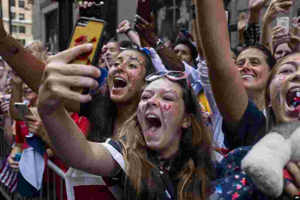 Fans celebrates as members of the the U.S. women's soccer team pass by during a ticker tape parade along the Canyon of Heroes in New York. The U.S. national team beat the Netherlands 2-0 to capture a record fourth Women's World Cup title.