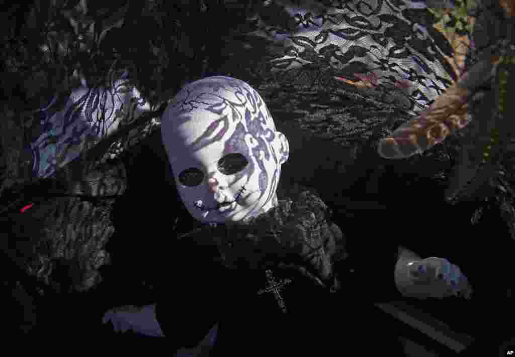 The shadows of a buggy textile fall on a puppet at the so-called 'Victorian Picnic' during the Wave Gothic Festival (WGT) in Leipzig, Germany.