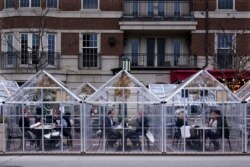 Diners eat in isolated dining rooms outside the Townhouse restaurant in Birmingham on March 25, 2021.