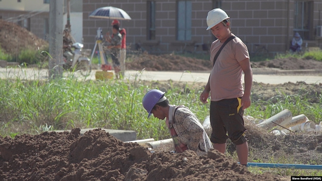 A Chinese engineer watches over a Burmese laborer at the construction site of the Chinese resort project, near Shwe Koko, Karen state, Myanmar.