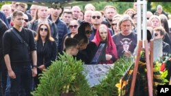 La gente reacciona junto al ataúd del jefe de logística del Grupo Wagner, Valery Chekalov, muerto en el accidente aéreo, durante un funeral en el cementerio Severnoye en San Petersburgo, Rusia, el martes 29 de agosto de 2023.