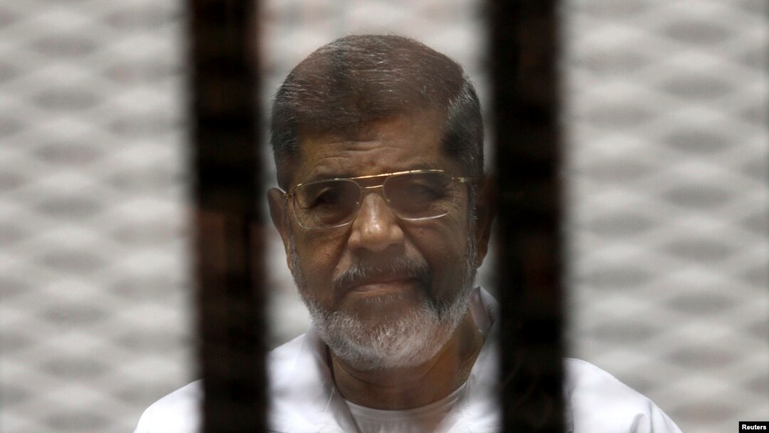 FILE - Ousted Egyptian President Mohamed Morsi is seen behind bars during his trial at a court in Cairo May 8, 2014.