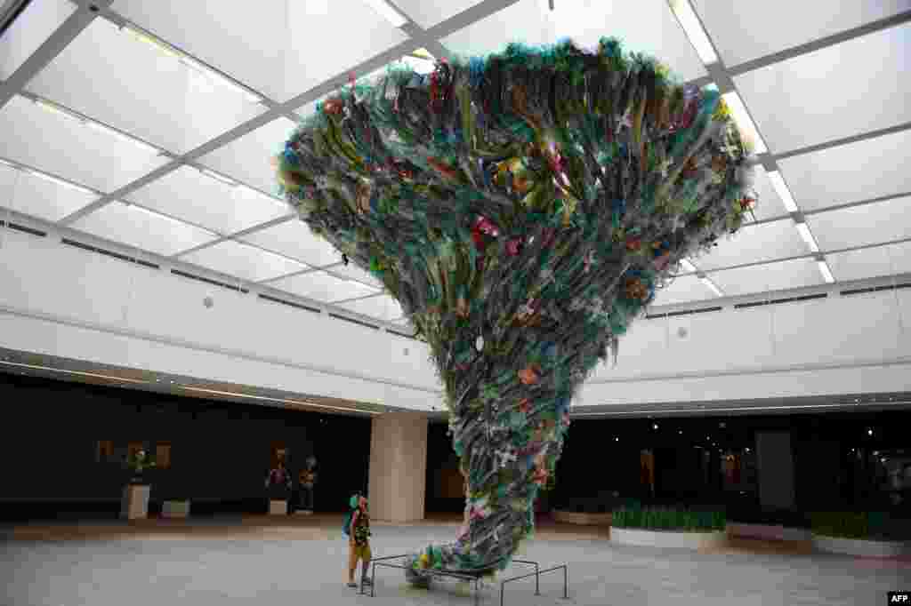 A boy looks up at the installation entitled 'Tornado by plastic waste' by artists from the social enterprise To He at the exhibition 'Plastics Planet' in Hanoi, Vietnam. (Nhac NGUYEN)