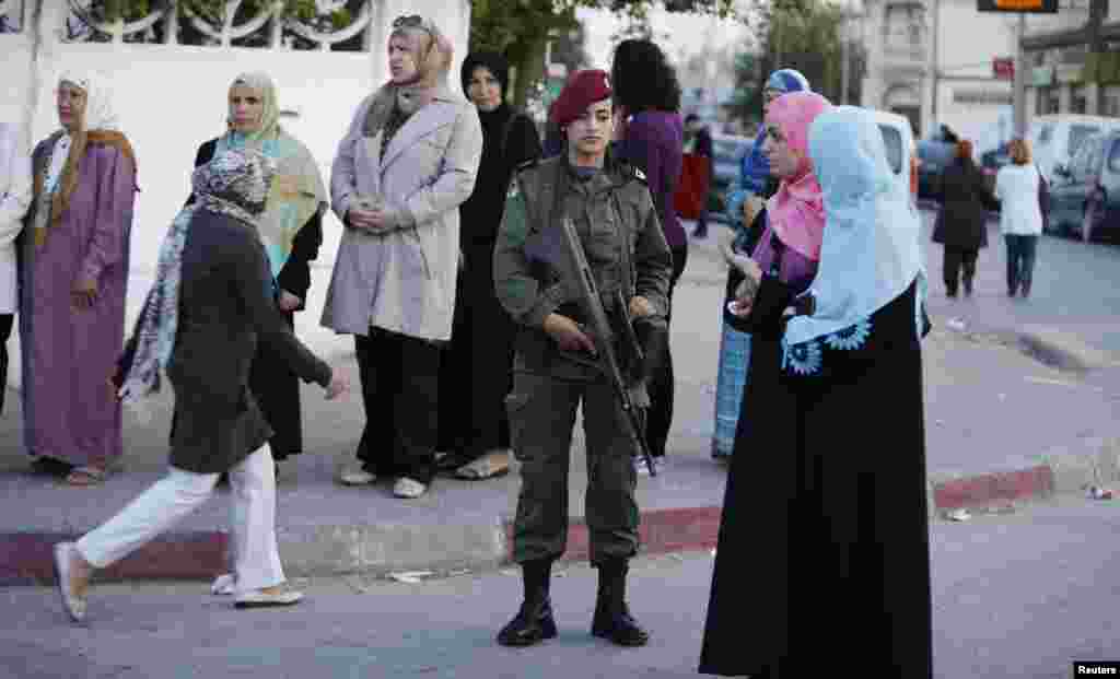 People stand in line at a polling station as they wait to cast their votes, in Tunisia, Oct. 26, 2014.