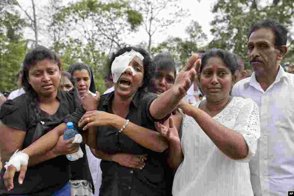 Anusha Kumari, center, weeps during a mass burial for her husband, two children and three siblings, all victims of Easter Sunday's bomb attacks, in Negombo, Sri Lanka.