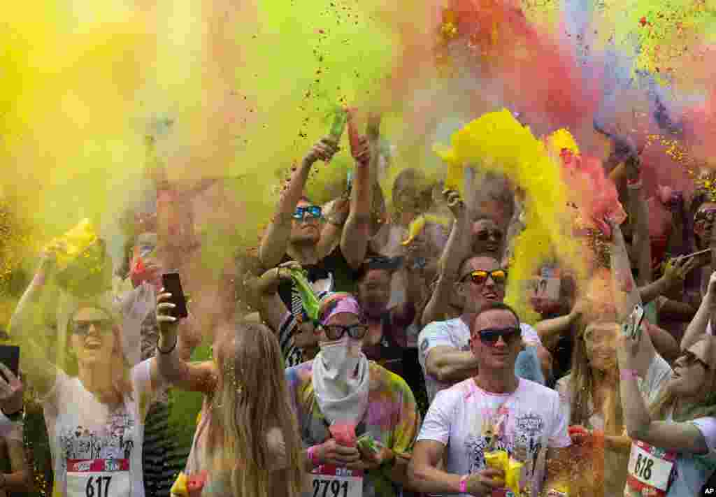 Runners throw paint powder after competing in the 5-kilometer (3-mile) 'Color Run' at the Luzhniki sports complex in Moscow, Russia.
