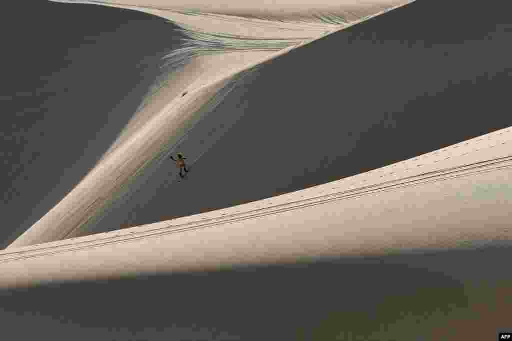 Nguyen Thai Binh rides down sand dunes on his snowboard in the southern Vietnamese town of Mui Ne.