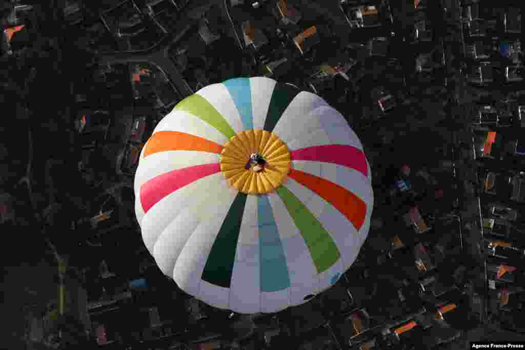 French balloonist Remi Ouvrard attempts to set a world record by standing on the top of a hot air balloon at an altitude of more than 3,637 meters in Chatellerault, France.