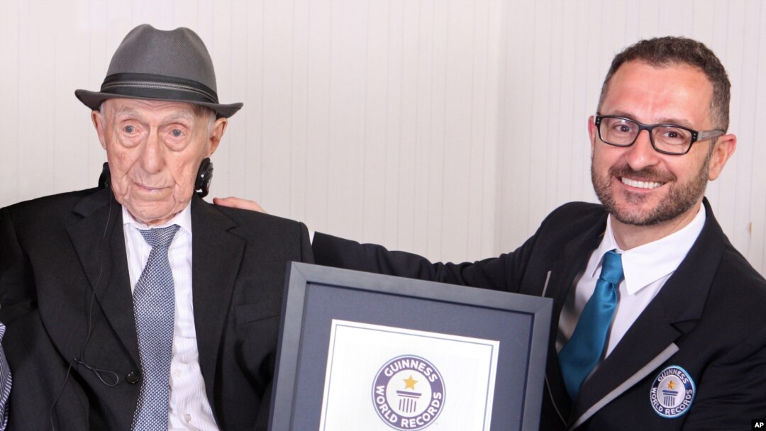 In this photo supplied by Guinness World Records, Marco Frigatti, head of records for Guinness World Records, presents Israel Kristal a certificate for being the oldest living man, in Haifa, Israel, March 11, 2016. 