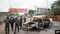 Border officials inspect a burnt-out Mozambican border patrol vehicle at the border crossing in Lebombo, South Africa, Nov. 7, 2024. 