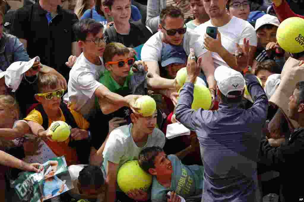 Spain's Rafael Nadal and his security guard, right, ask fans to calm down to prevent children from getting crushed after Nadal's second round match of the French Open tennis tournament against Germany's Yannick Maden at the Roland Garros stadium in Paris.