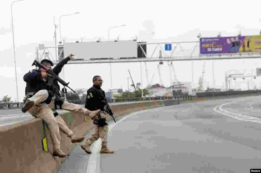 Federal police officers are seen at the Rio-Niteroi Bridge, where armed police surrounded a hijacked passenger bus in Rio de Janeiro, Brazil.