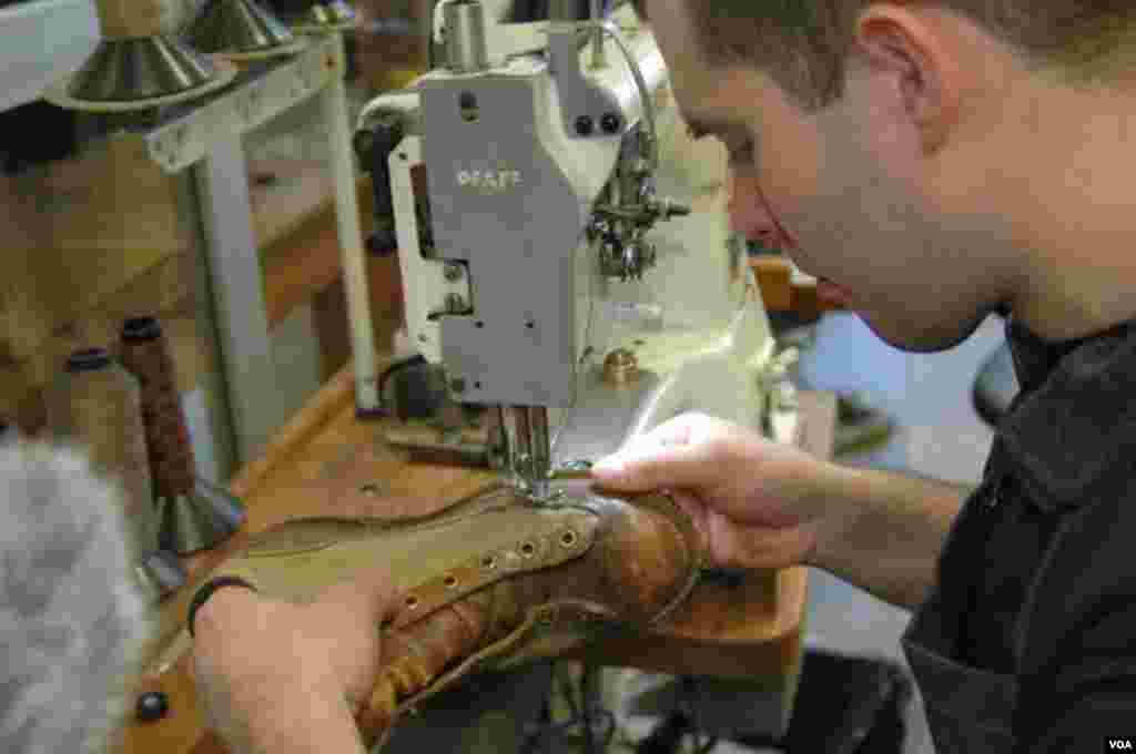 Putting replacement stitching around the old boot, Portland, Oregon, Jan. 20, 2014. (Steve Herman/VOA)