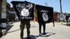 Young men carry Islamic State banners during an anti-government demonstration in Indian-administered Kashmir, June 27, 2015. (Credit: Tajamul Lone/VOA)