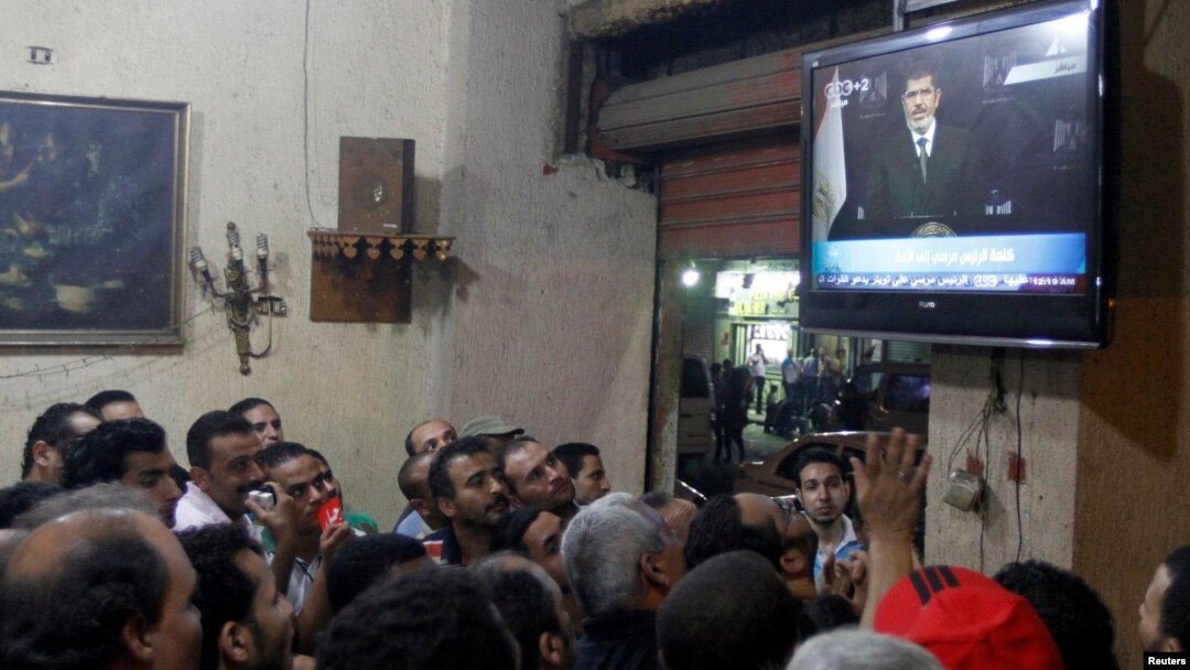 Anti-President Mohamed Morsi protesters watch a speech by him on TV at a cafe in Tahrir Square in Cairo, July 2, 2013.