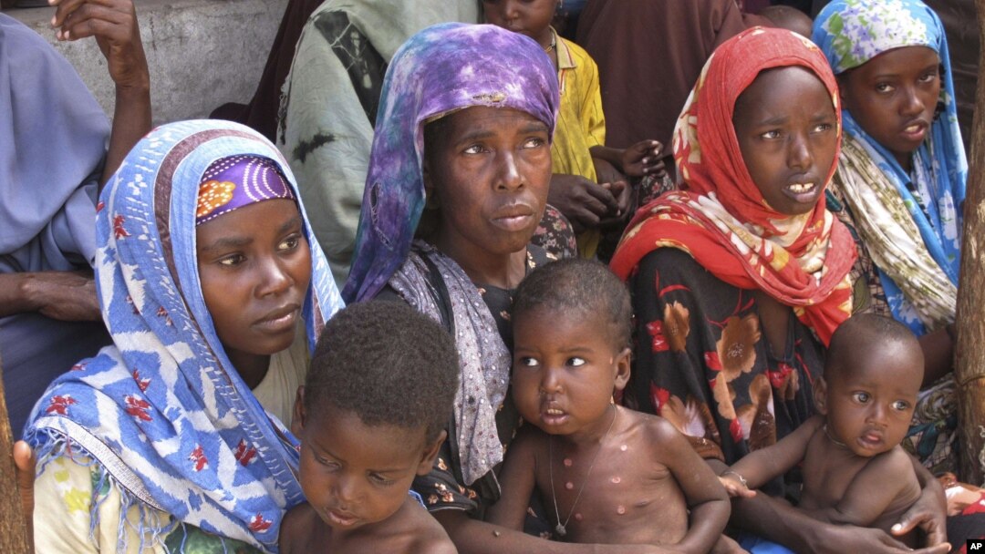 Mothers from southern Somalia hold their children at medical center in Mogadishu, Somalia, August 3, 2011.