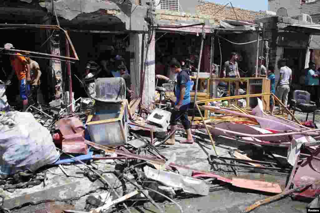Residents inspect the site of a car bomb attack in Basra, Iraq, July 29, 2013. 