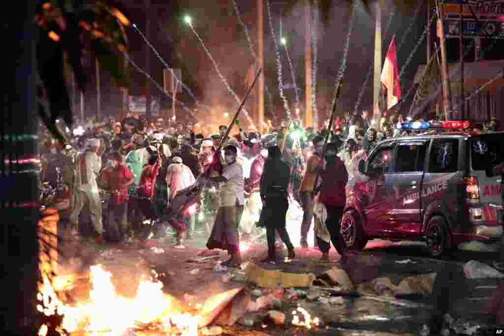Fire crackers explode near supporters of presidential candidate Prabowo Subianto during clashes with the police in Jakarta, Indonesia. President Joko Widodo said authorities have the volatile situation in the country's capital under control after six people died in riots by supporters of his losing rival in last month's presidential election.