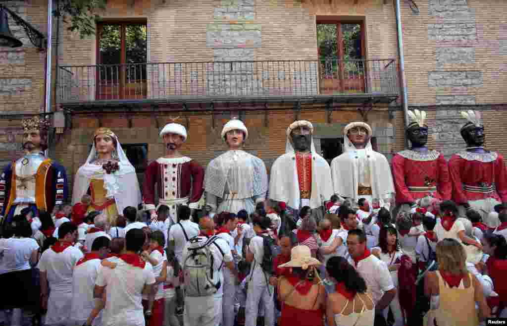 Revelers take part in the "Comparsa de gigantes y cabezudos" (Giants and Big Heads Parade) during the San Fermin festival in Pamplona, Spain.