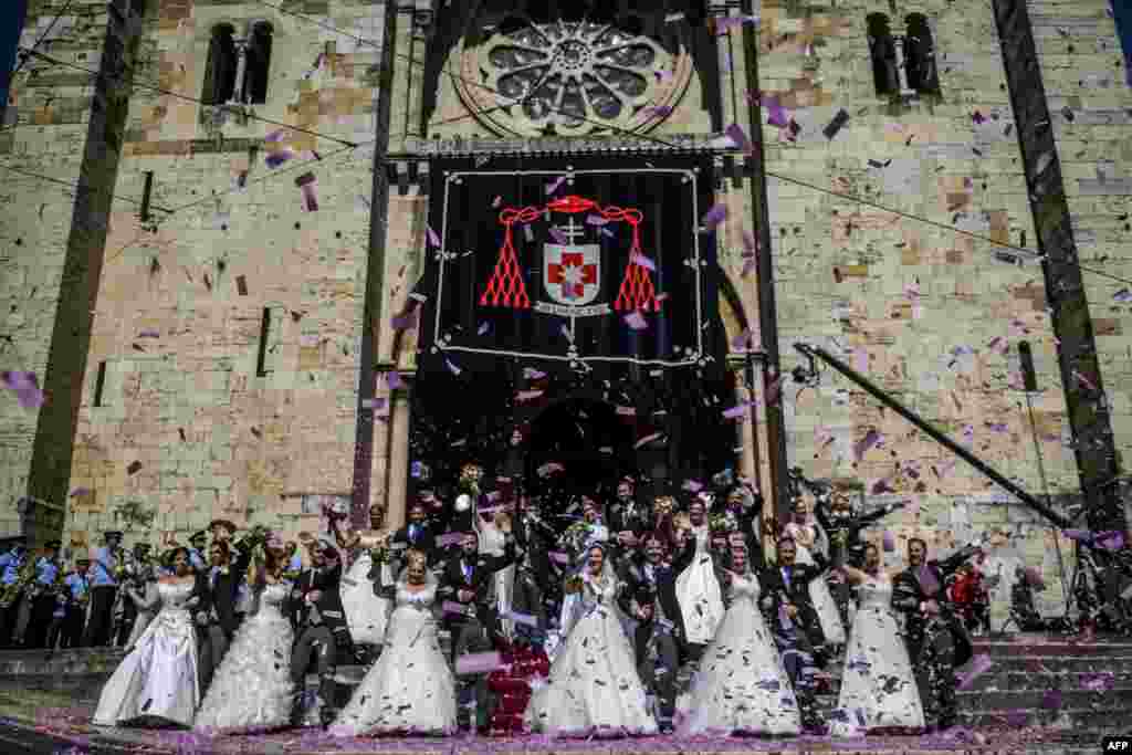 Brides and grooms pose for a photo outside the Lisbon's cathedral following their wedding ceremony in Lisbon, Portugal, June 12, 2019.