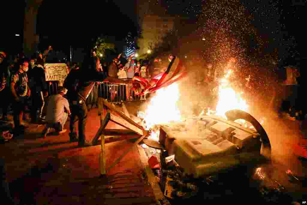 Demonstrators start a fire as they protest the death of George Floyd, May 31, 2020, near the White House in Washington.