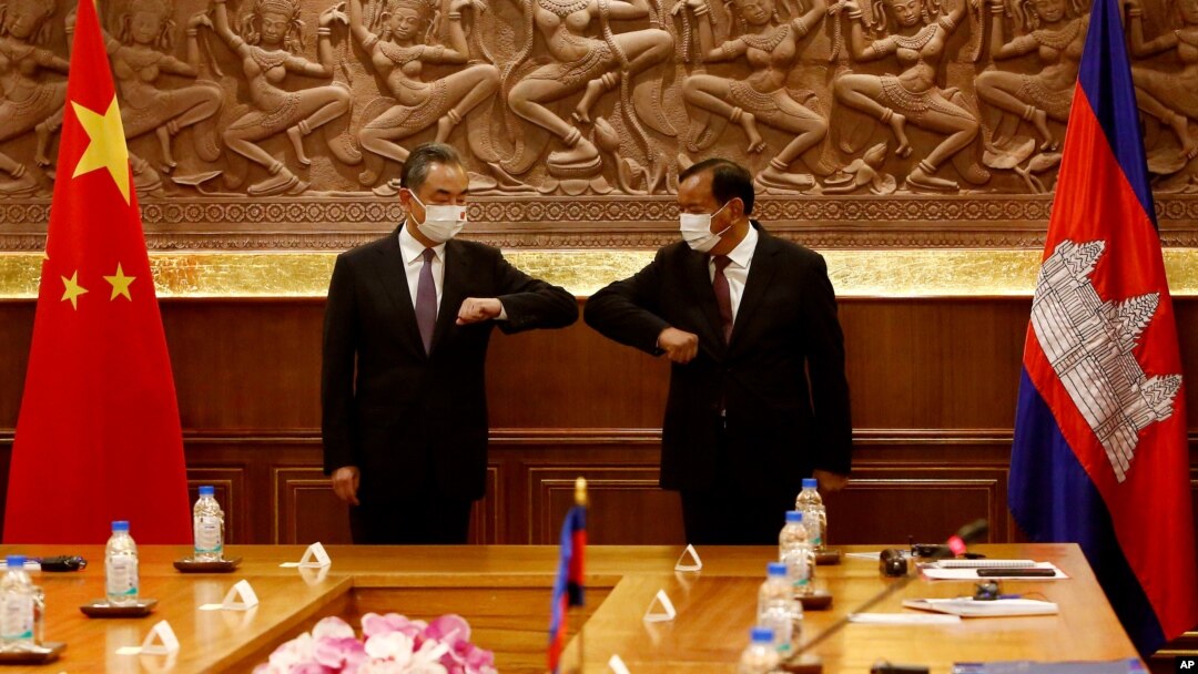 Chinese Foreign Minister Wang Yi, left, greets with Cambodian counterpart Prak Sokhonn in Phnom Penh, Cambodia, Sept. 12, 2021.