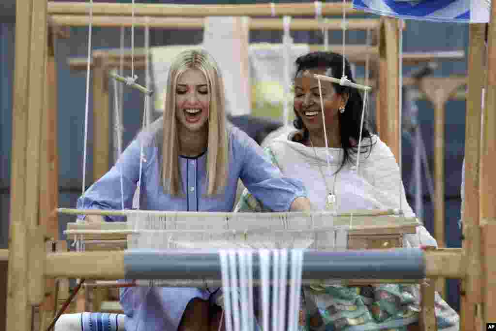 White House senior adviser Ivanka Trump, left, reacts as she tries a traditional weaving loom at Muya, a manufacturing center of textile and traditional crafts, with Muya founder Sara Abera, in Addis Ababa, Ethiopia.
