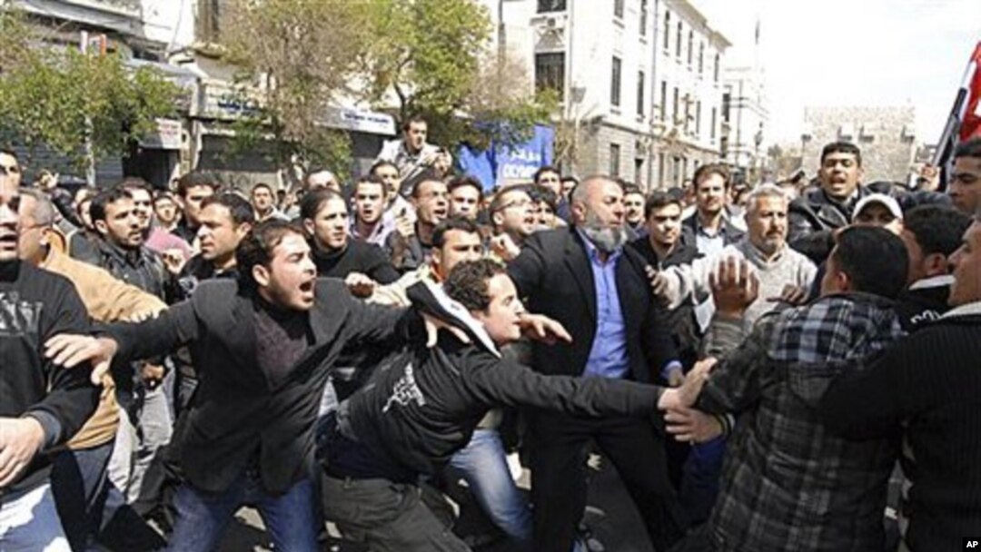 Syrians anti and pro-Assad protesters clash after Friday prayers in Damascus, March 25, 2011