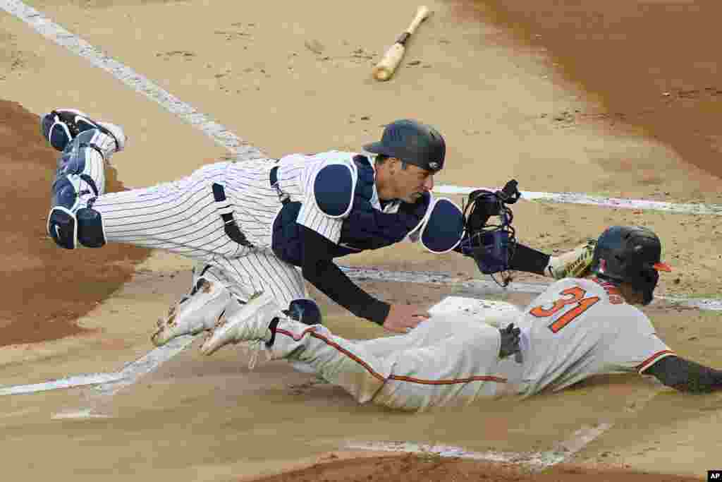 New York Yankees catcher Kyle Higashioka (66) tags Baltimore Orioles Cedric Mullins (31) out at the plate on a fielder's choice during the first inning of a baseball game, April 6, 2021, at Yankee Stadium in New York.