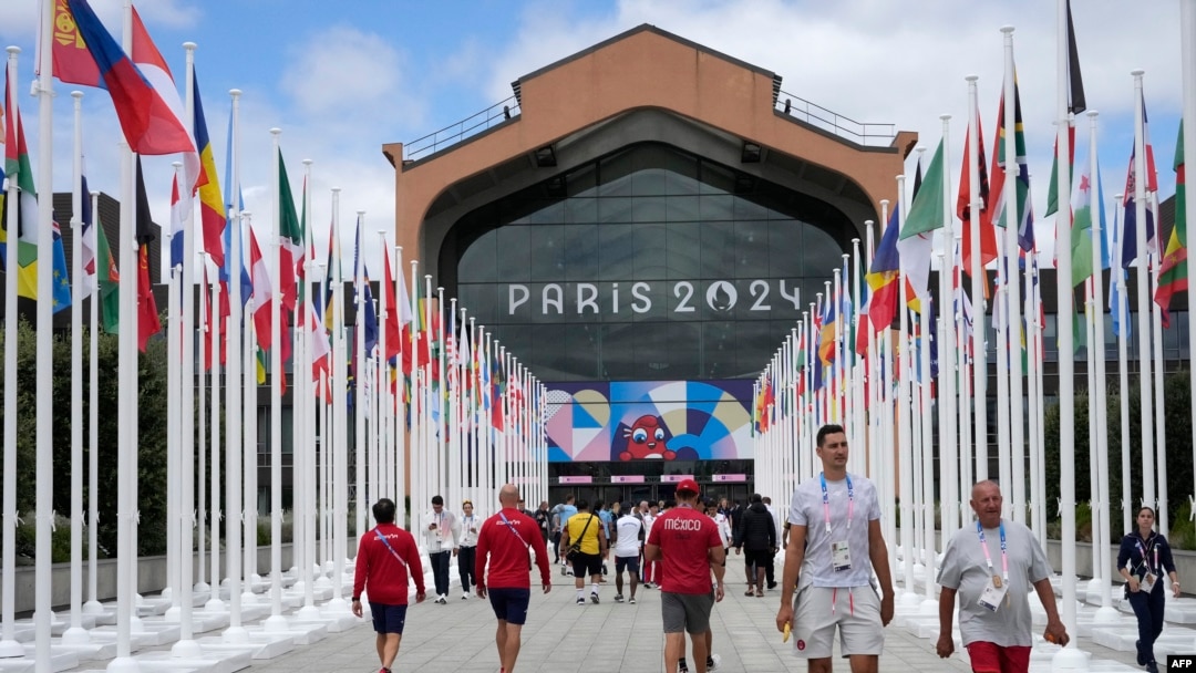 ARCHIVO -Participantes de los Juegos Olímpicos y Paralímpicos de París 2024 caminan frente a la cafetería de la Villa Olímpica, en Saint-Denis, al norte de París, el 22 de julio de 2024, antes de la ceremonia de apertura de los Juegos Olímpicos y Paralímpicos de París 2024.