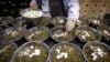 FILE - In this March 13, 2020 photo, a worker assembles ingredients for traditional Chinese medicine preparations into bowls at the Bo Ai Tang traditional Chinese medicine clinic in Beijing.
