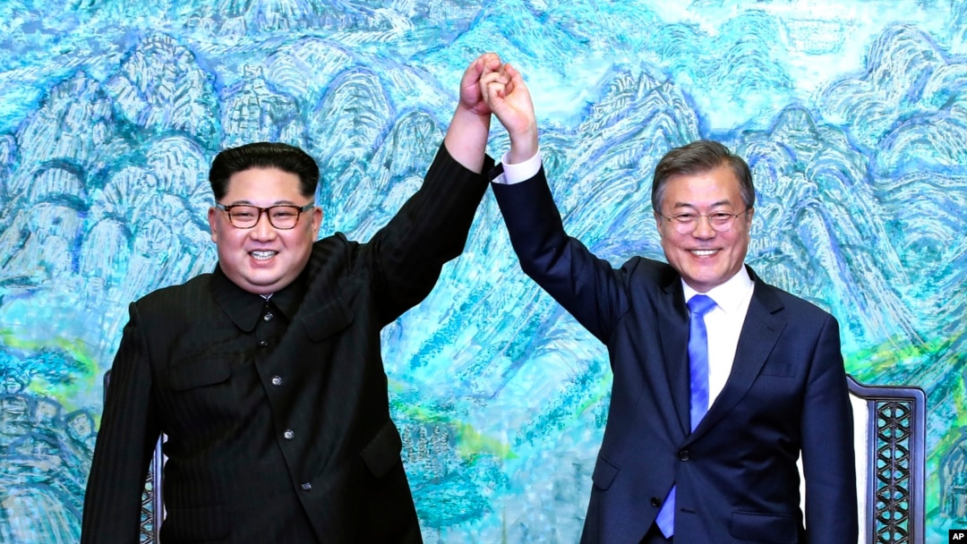 North Korean leader Kim Jong Un, left, and South Korean President Moon Jae-in raise their hands after signing a joint statement at the border village of Panmunjom in the Demilitarized Zone, South Korea, April 27, 2018.