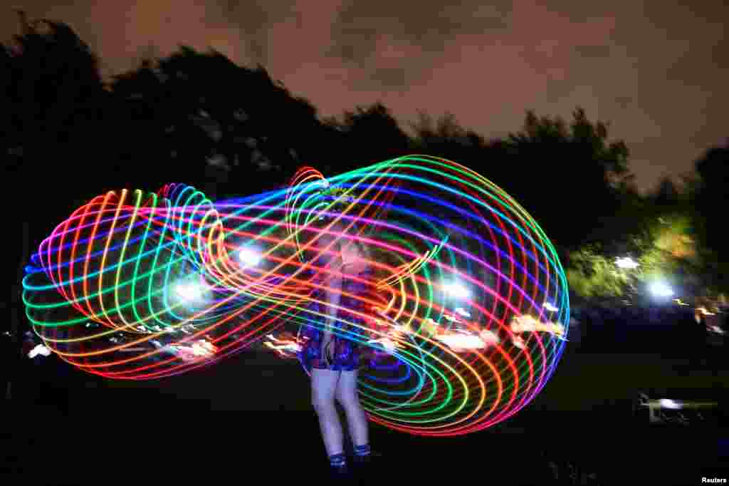 A woman dances with light at an event called 'Catharsis on the Mall' in Washington, May 4, 2019.