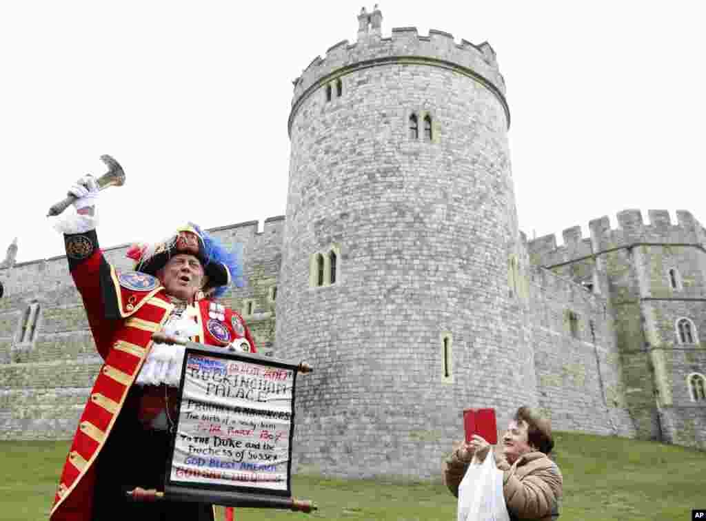 An unofficial Town Crier announces the birth of a baby boy born to Britain's Prince Harry and Meghan, the Duchess of Sussex, outside Windsor Castle in Windsor, south England.