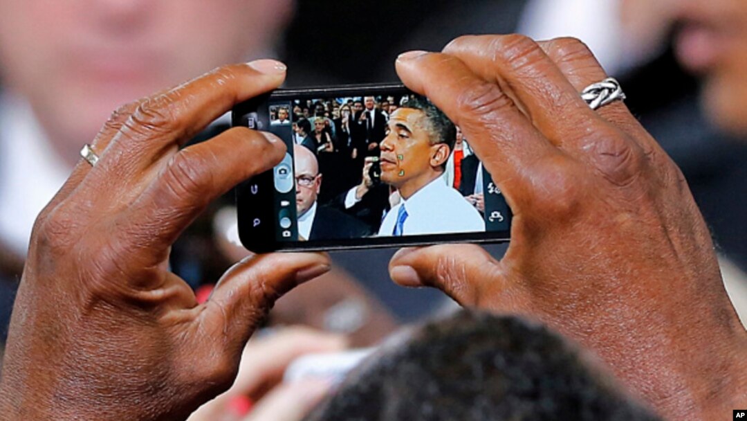 President Barack Obama is seen on a phone camera as he greets the crowd after speaking in Phoenix, Arizona, Aug. 6, 2013.