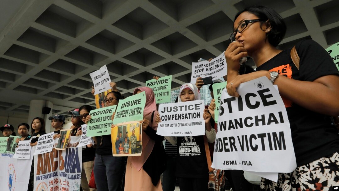 FILE - A migrant workers alliance group holds placards to protest the killings of two Indonesian women in 2014, outside the High Court in Hong Kong, Oct. 24, 2016. 