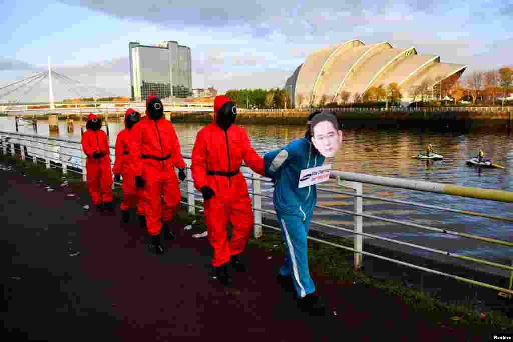 Climate activists, dressed as characters inspired by the Netflix series "Squid Game," protest as they ask Samsung to use 100% renewable energy, outside the venue for the U.N. Climate Change Conference (COP26) in Glasgow, Scotland.