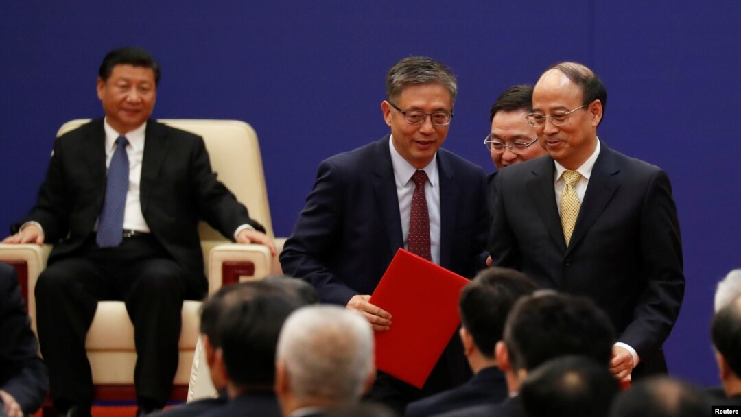 FILE - Vice chairman and president of China Investment Corporations (CIC) Tu Guangshao, chairman of the Board of Directors of the Bank of China Chen Siqing and president of Sinopec Group Dai Houliang attend signing ceremony and meeting of business leaders with U.S. President Donald Trump and China's President Xi Jinping at the Great Hall of the People in Beijing, China, Nov. 9, 2017. 