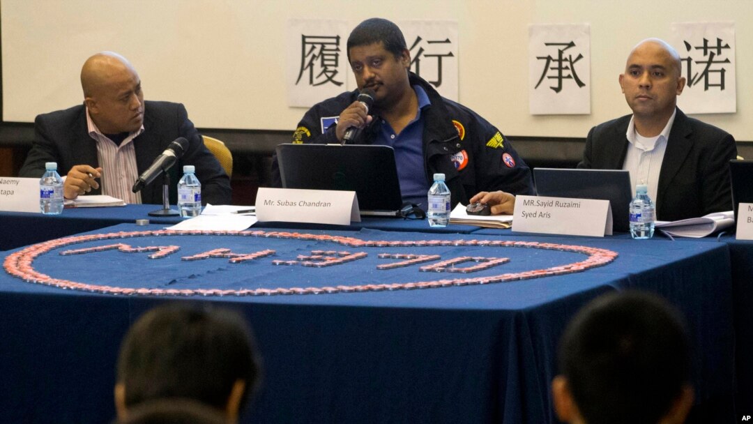 Representantes de Malaysia Airlines dan explicaciones sobre la desaparición del vuelo 370 a parientes de las víctimas.