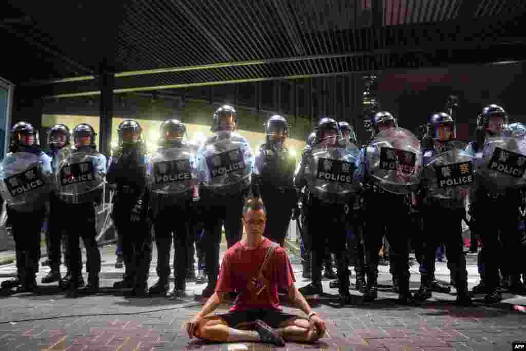 A protester meditates in front of police in Hong Kong, June 10, 2019. Hong Kong witnessed its largest street protest in at least 15 years as crowds massed against plans to allow extraditions to China, a proposal that has sparked a major backlash against the city's pro-Beijing leadership.